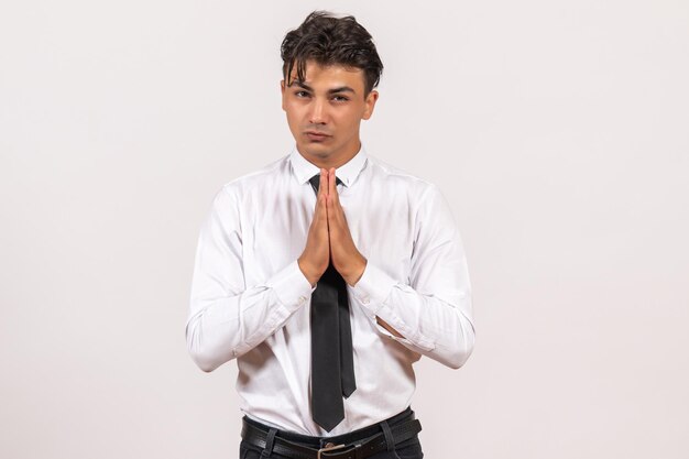 Front view male office worker praying on white wall work male job business