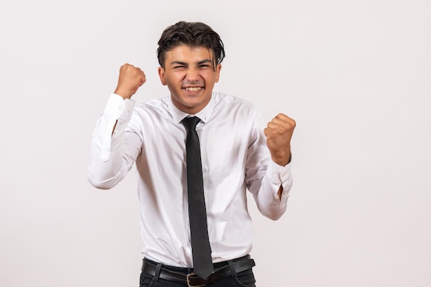 Front view male office worker rejoicing on white wall work male job business