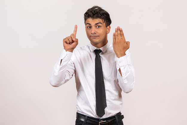 Front view male office worker standing on white wall work business male job