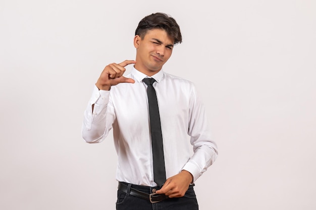 Front view male office worker with displeased face on white desk human office work job male