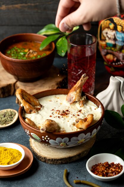 Front view male pepper fried chicken in sauce on a stand with spices on the table