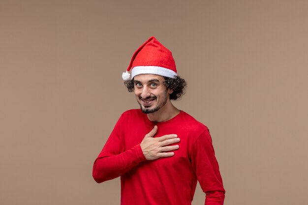 Front view male in red bowing and smiling on brown background holiday emotion christmas