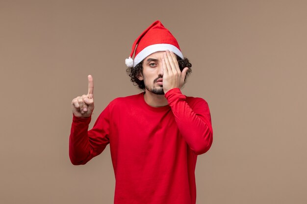 Front view male in red covering half of his face on brown background holiday emotion christmas