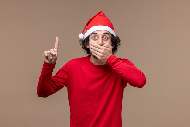 Free photo front view male in red with shocked expression on brown background holiday emotion christmas