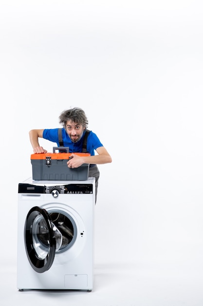 空白の洗濯機にツールバッグを置く正面図男性修理工