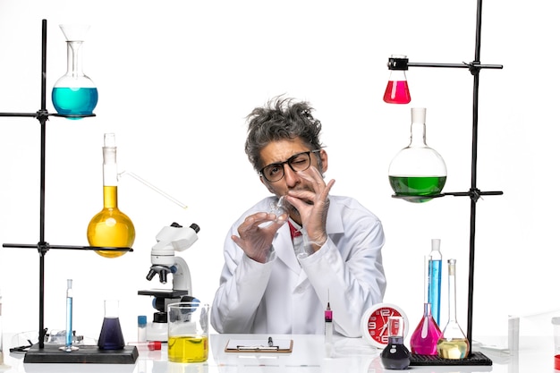 Вид спереди ученый-мужчина в медицинском костюме, держащий пустую фляжку на белом фоне, вирус химии здоровья covid- lab