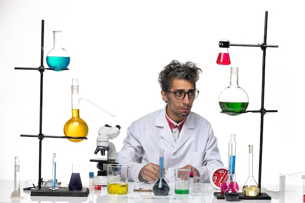 Вид спереди ученый-мужчина в медицинском костюме, работающий с растворами