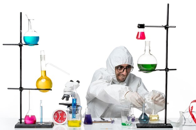 Front view male scientist in special protective suit holding flasks with solutions