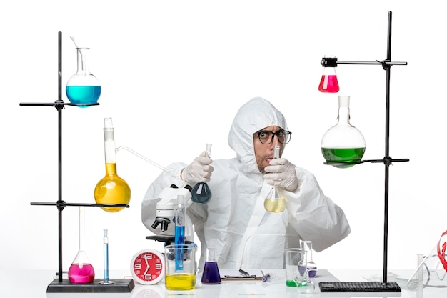 Free photo front view male scientist in special protective suit holding flasks with solutions