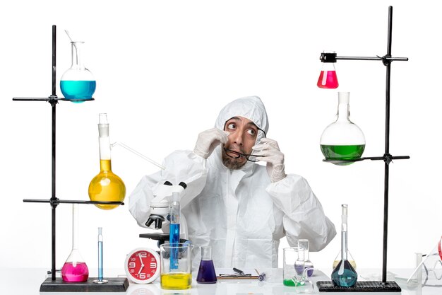 Free photo front view male scientist in special protective suit sitting around desk with solutions