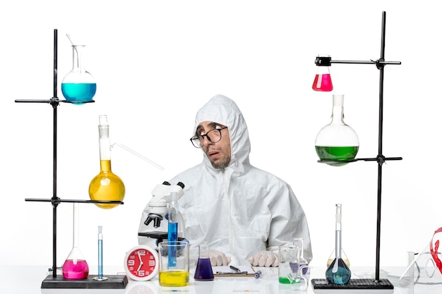 Free photo front view male scientist in special protective suit sitting around desk with solutions