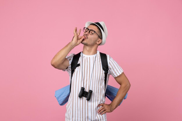 Front view male tourist walking with backpack on the pink wall color emotion tourist