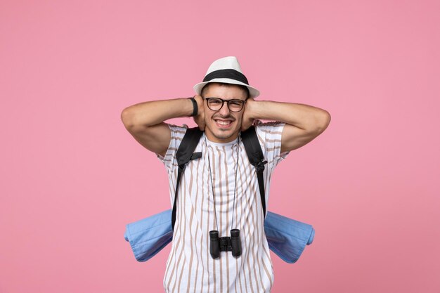 Front view male tourist with his backpack on pink wall color emotion tourist