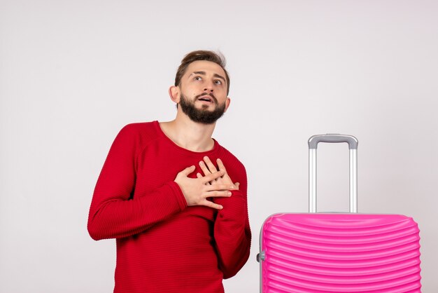 Front view male tourist with pink bag on white wall photo voyage tourism emotion color vacation