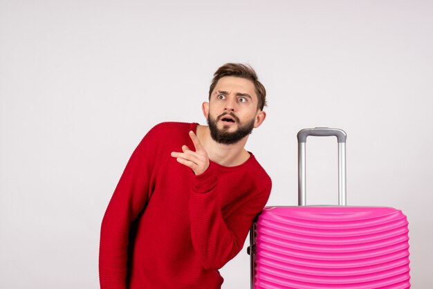 Front view male tourist with pink bag on a white wall