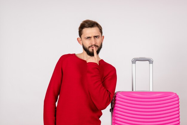 Front view male tourist with pink bag on white wall 