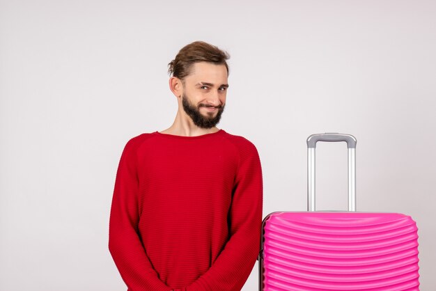 Front view male tourist with pink bag on white wall