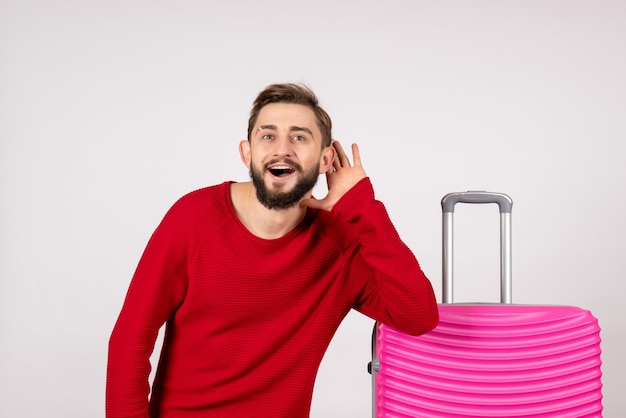 Front view male tourist with pink bag on white wall