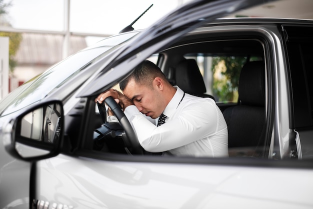 Free photo front view male with head leaning on steer wheel wheel