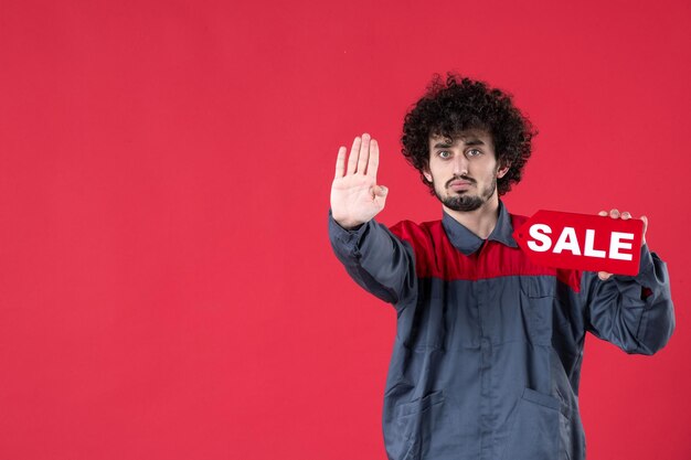 Front view male worker holding red sale nameplate on red