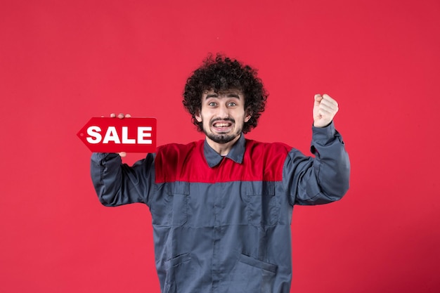 Front view male worker holding red sale nameplate on red