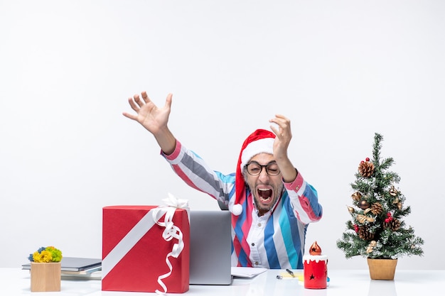 Front view male worker sitting in his place using laptop screaming emotion office christmas job