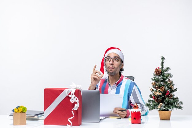 노트북 및 문서 크리스마스 사무실을 들고 파일과 함께 자신의 자리에 앉아 전면보기 남성 노동자