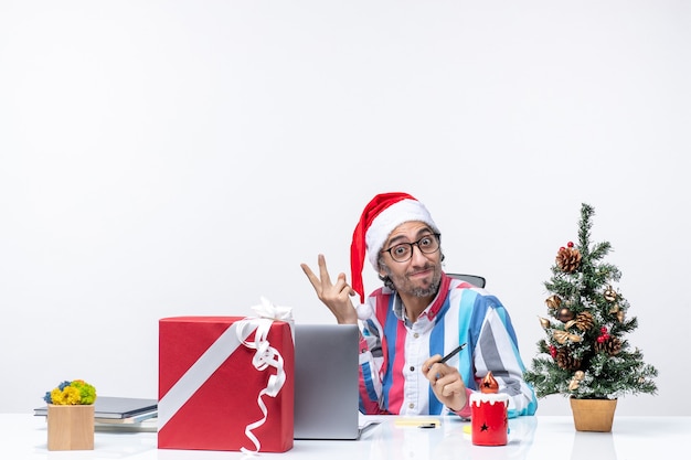 노트북 및 사무실 직업 크리스마스 감정을 포즈 파일과 함께 자신의 자리에 앉아 전면보기 남성 노동자