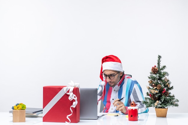 Front view male worker sitting in his place with laptop and files working office emotion job xmas