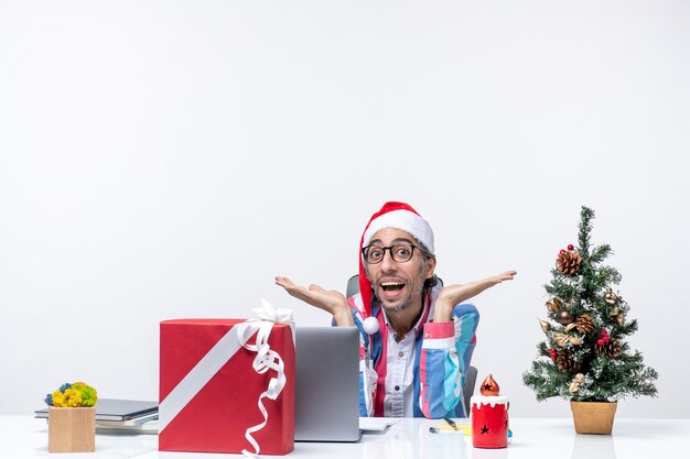 Front view male worker sitting in his working place business christmas job emotion