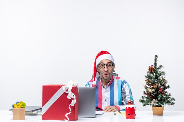 Вид спереди мужчина-работник, сидящий на своем рабочем месте, эмоция, бизнес, рождественская работа