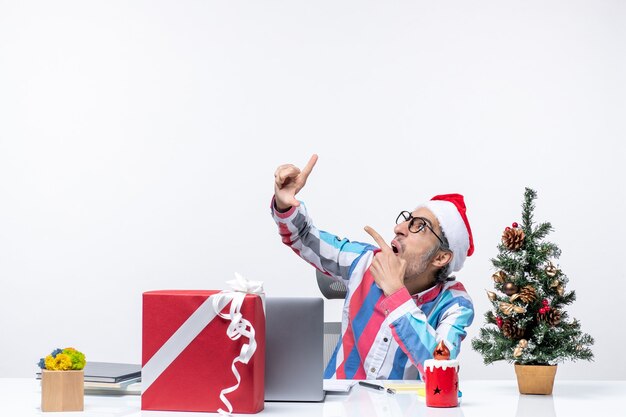 Foto gratuita vista frontale lavoratore maschio seduto nel suo posto di lavoro ufficio emotivo lavoro d'affari natale emozione