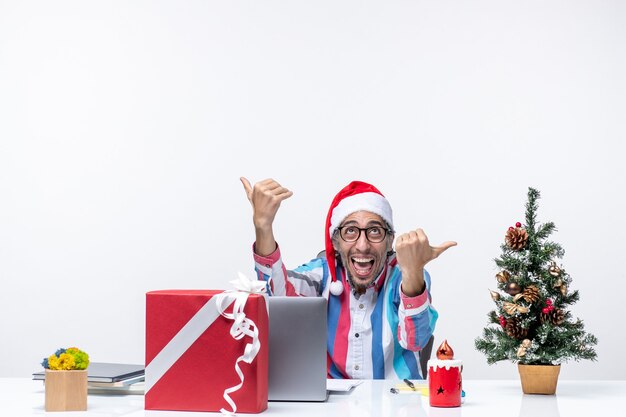 Front view male worker sitting in his working place feeling excited business christmas job emotion