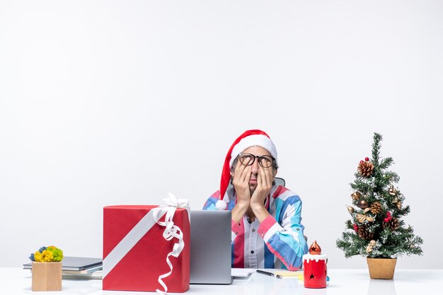 Вид спереди мужчина-работник сидит на своем рабочем месте, чувствуя усталость, рождественский бизнес, работа, эмоция