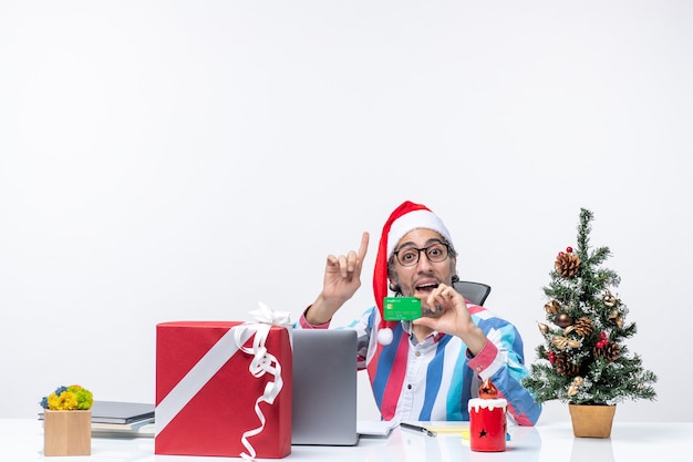 Front view male worker sitting in his working place holding green bank card money job office xmas emotion