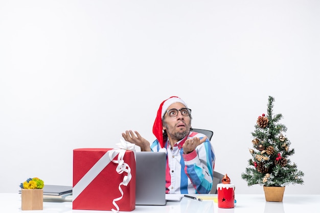 Front view male worker sitting in his working place office emotion job christmas business