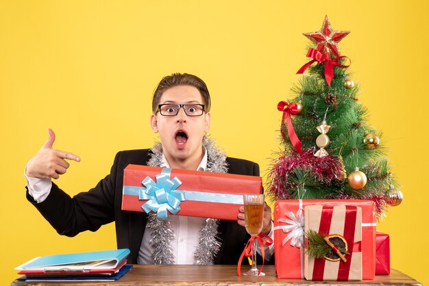 クリスマスプレゼントを座って保持している正面図男性労働者