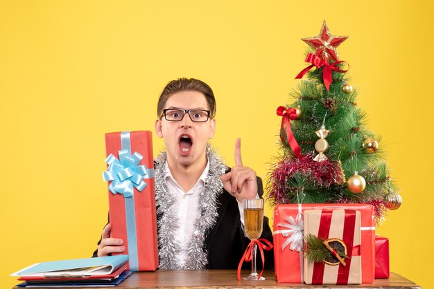 Front view male worker sitting with christmas presents