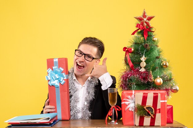 Front view male worker sitting with christmas presents