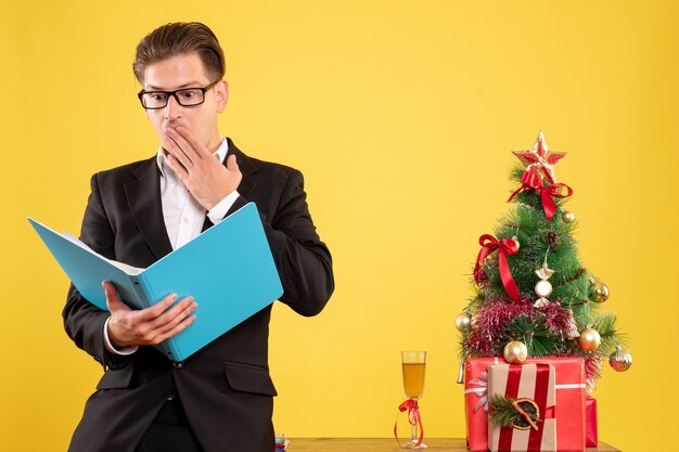 Front view male worker in suit standing and reading documents