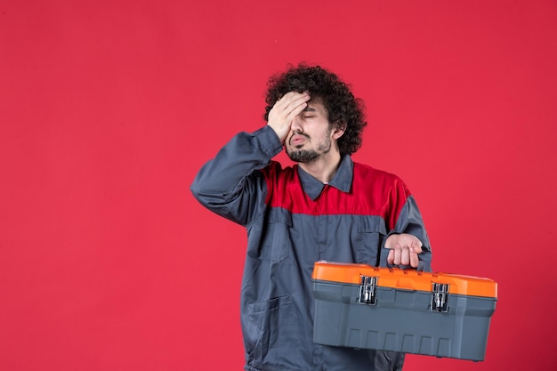 Free photo front view male worker with tool case on red background photo color worker mechanic instrument job emotion uniform