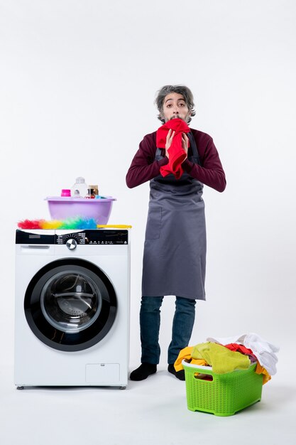 Front view man in apron wiping his face with towel on white wall