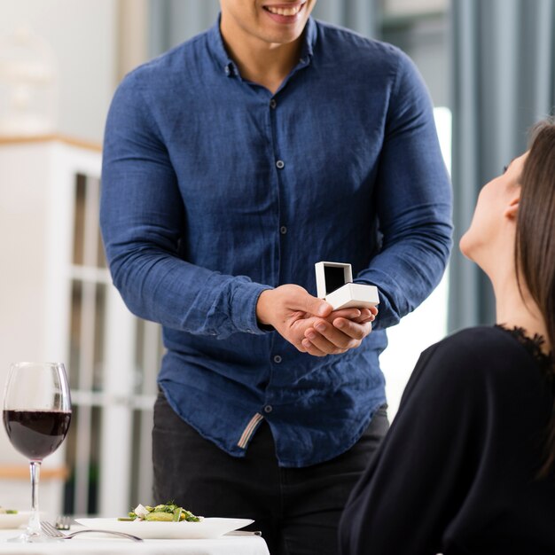 Front view man asking his girlfriend to marry him