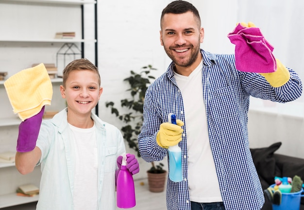 Front view of man and boy posing while cleaning the house