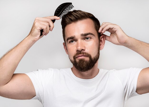 Front view man brushing his hair