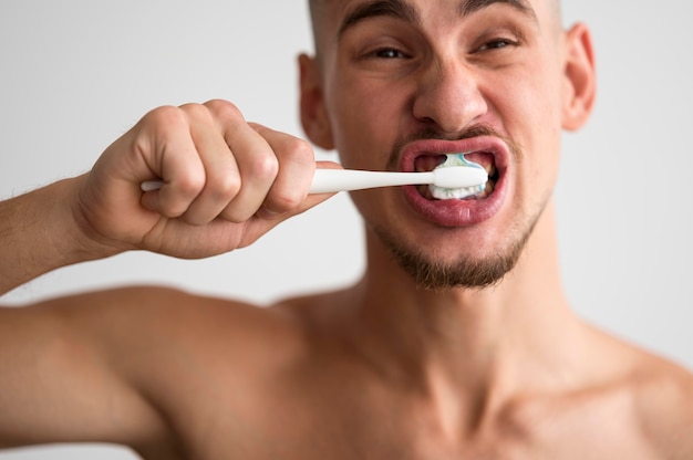 Front view of man brushing his teeth in the morning