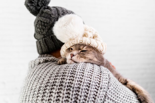 Front view man and cat wearing both fur cap