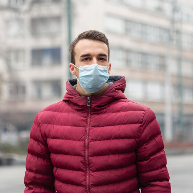 Front view of man in the city wearing medical mask