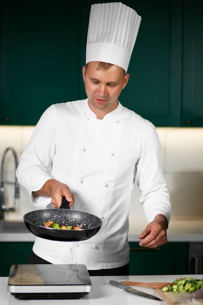 Front view man cooking in kitchen