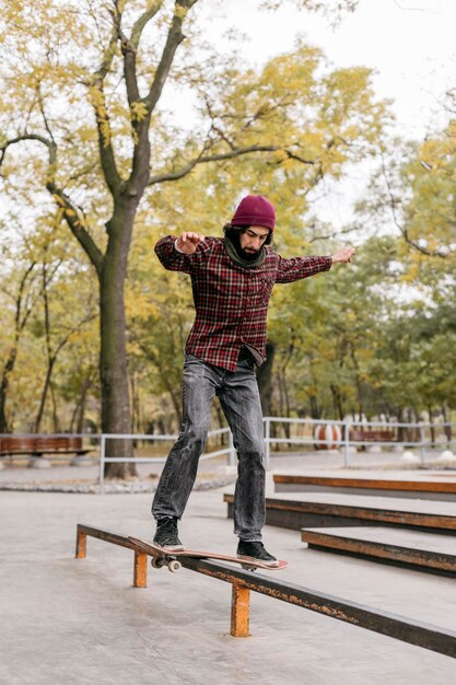 Front view of man doing tricks with skateboard outside